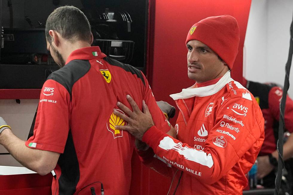 Ferrari driver Carlos Sainz, of Spain, talks with his a team member before the final practice s ...