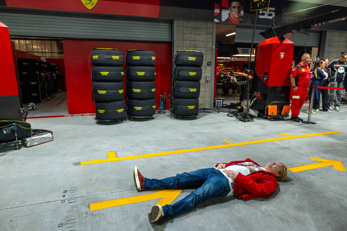 Racing fan Jack Corddry of Tacoma lays down in the garage pit of Ferrari driver Carlos Sainz du ...
