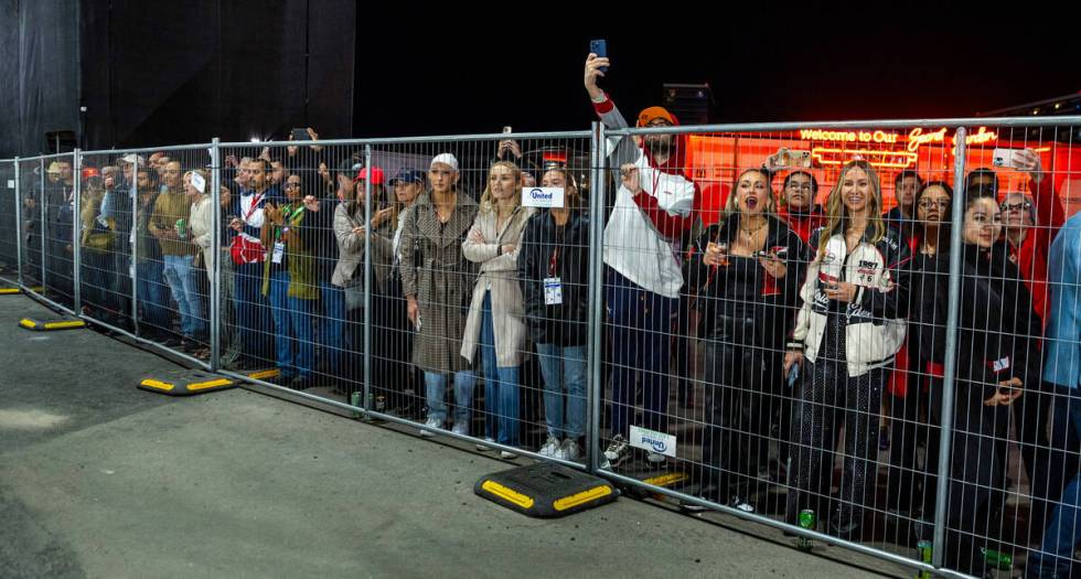 Fans watch the race from behind a fence near turn one during the Las Vegas Grand Prix Formula O ...