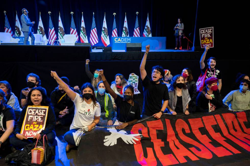 Pro-Palestinian demonstrators sit in front of the stage, disrupting the afternoon session of th ...