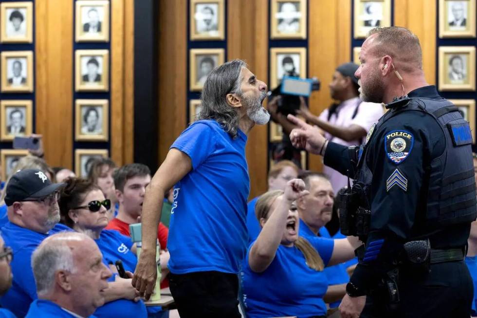 Aramis Bacallao, a teacher at Becker Middle School, shouts while being removed from a school bo ...