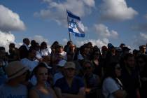A woman holds an Israeli flag as family members and friends attend the funeral of the head of t ...
