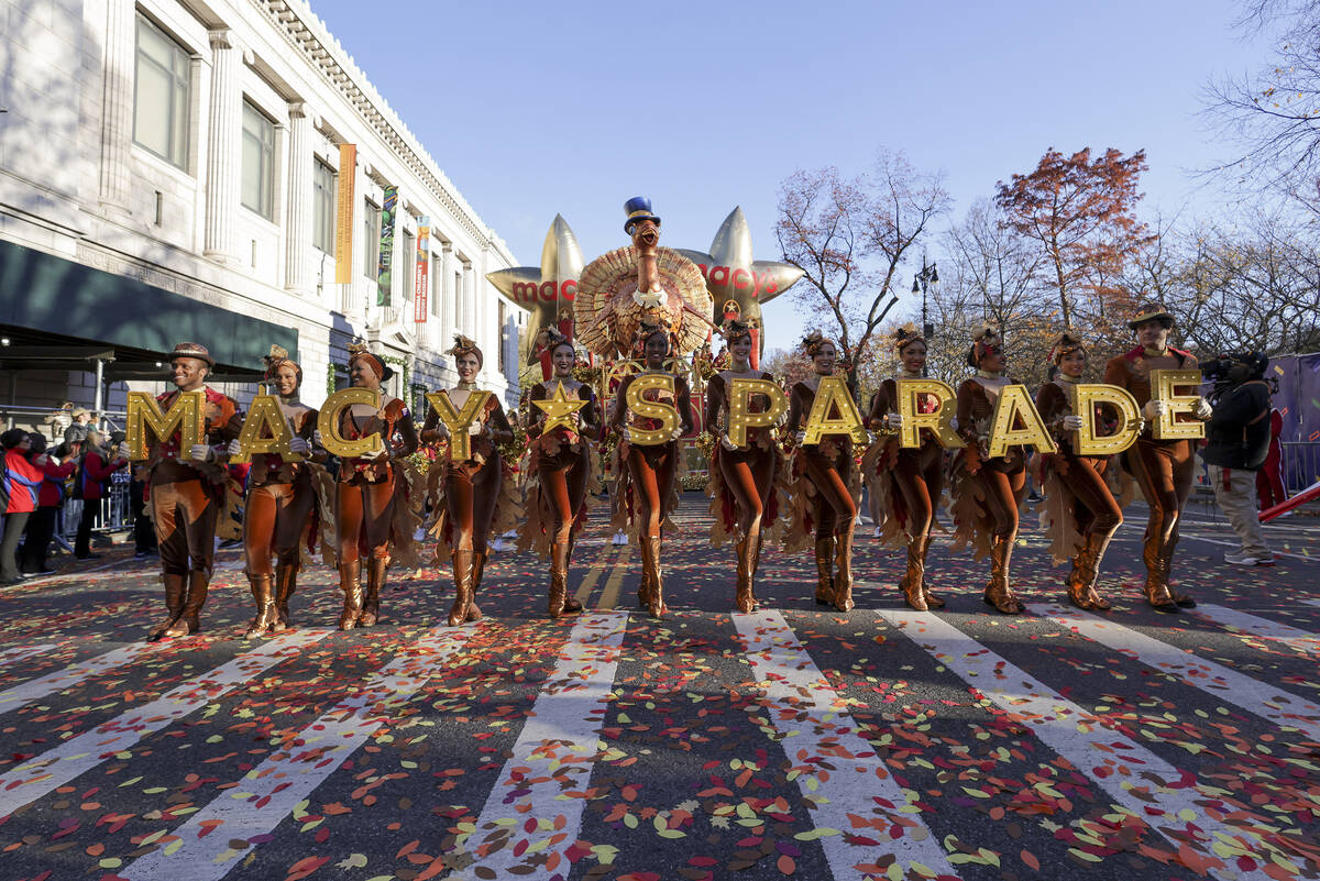 Parade performers lead the Tom Turkey float down Central Park West at the start of the Macy's T ...