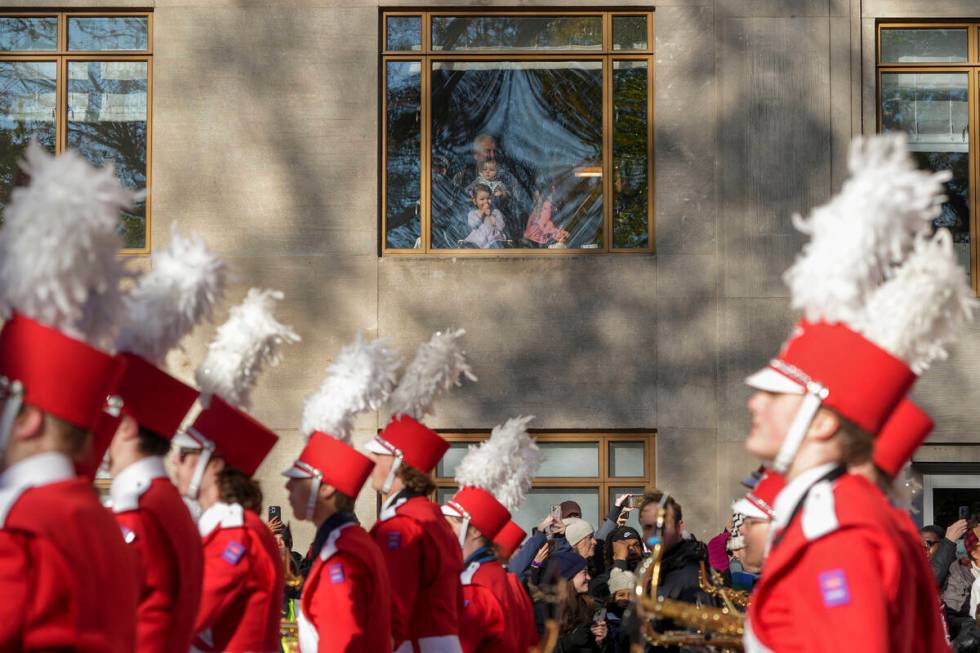 Spectators watch as a marching band passes by along Central Park West during the Macy's Thanksg ...