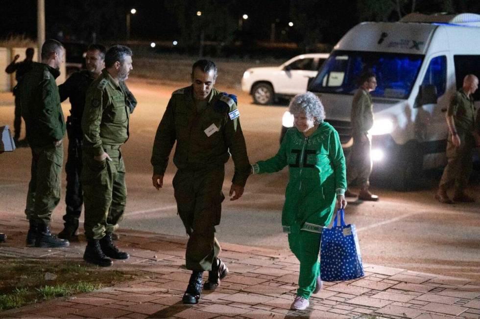 Ruth Munder, a released Israeli hostage, walks with an Israeli soldier shortly after her arriva ...