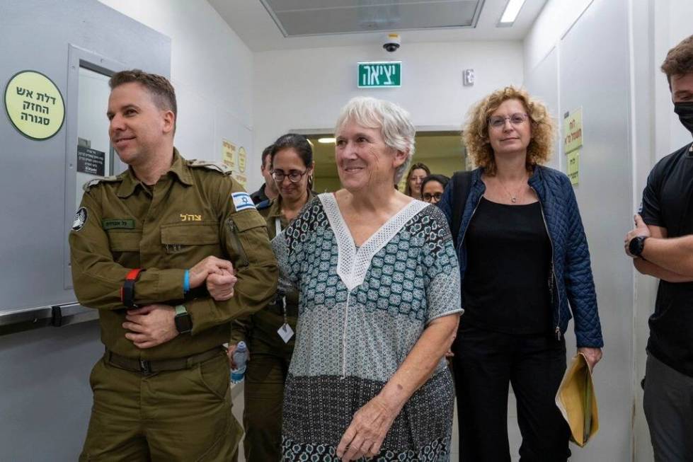 Margalit Mozes, a released Israeli hostage, walks with an Israeli soldier shortly after her arr ...