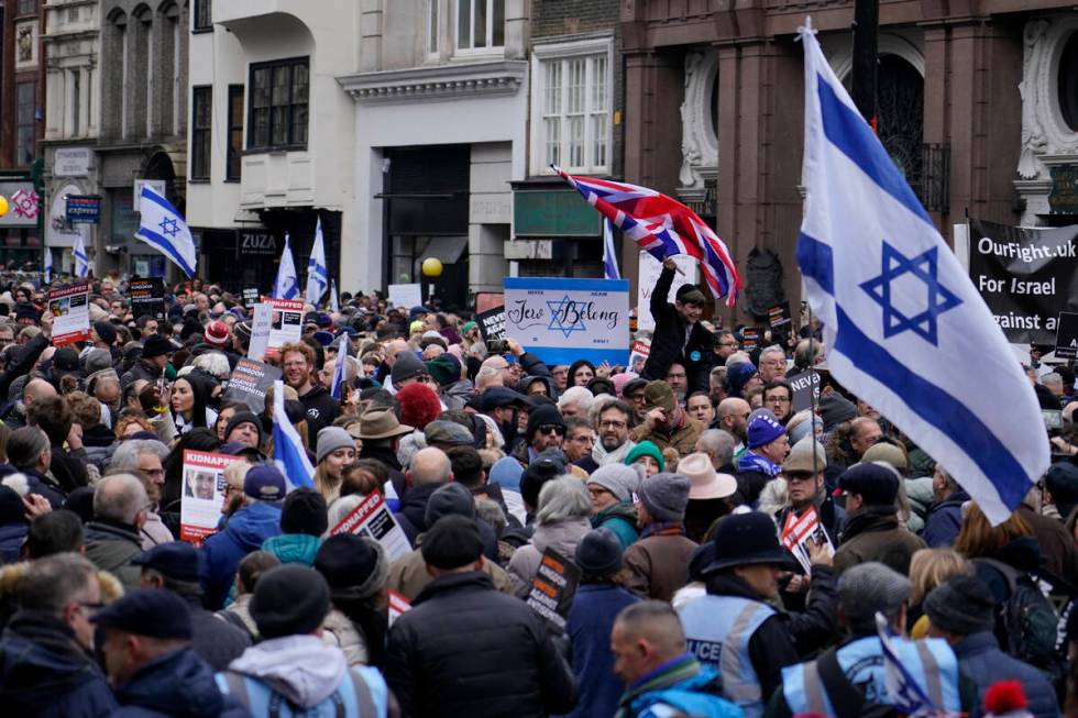 Protesters holding placards flags and banners, including the flag of Israel, during an anti-Sem ...