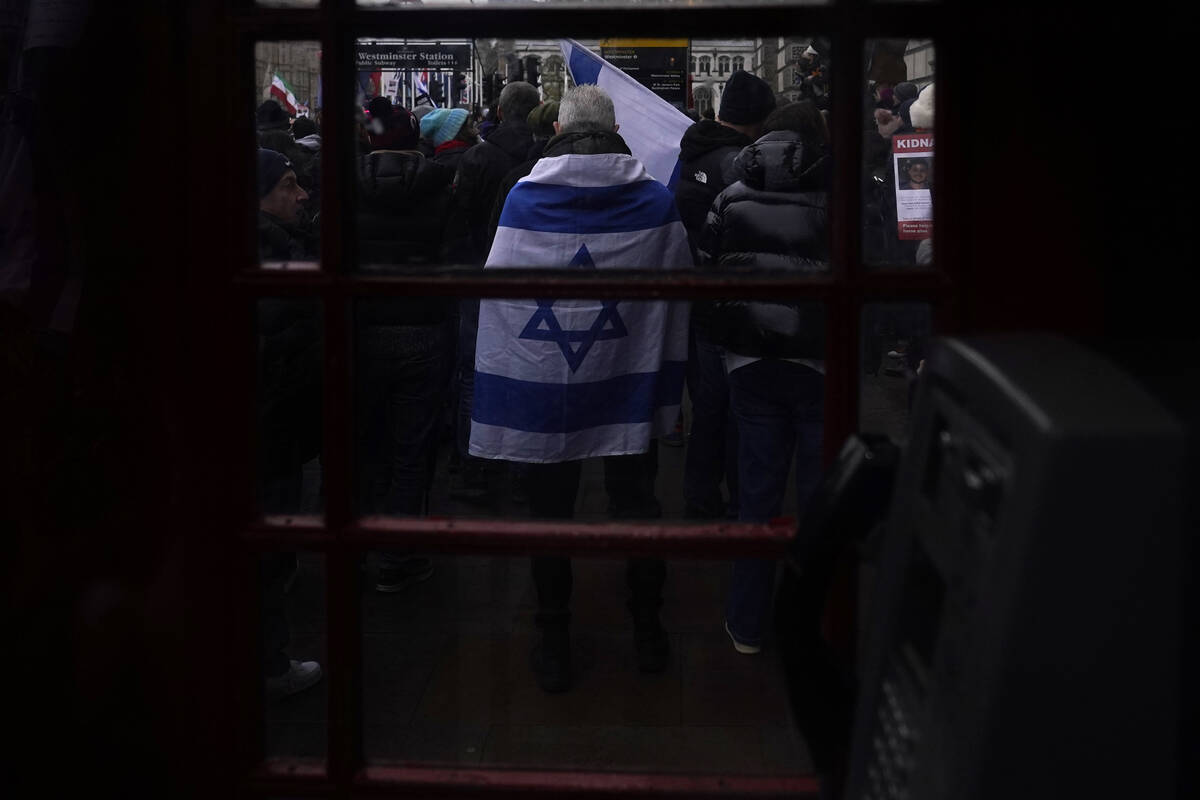 A man wrapped in an Israeli flag takes part in an anti-Semitism demonstration near Parliament S ...