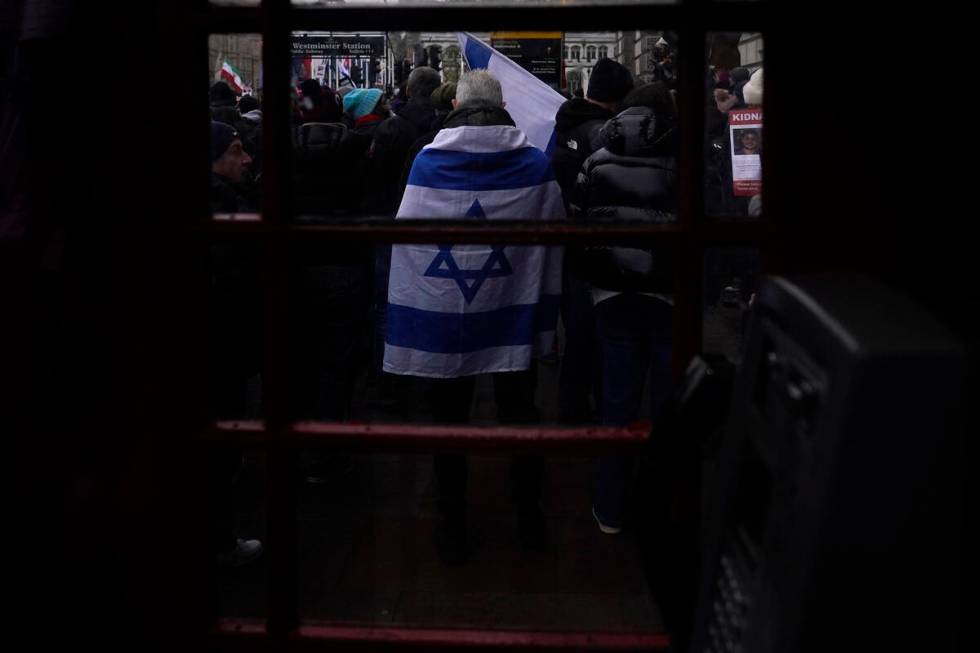 A man wrapped in an Israeli flag takes part in an anti-Semitism demonstration near Parliament S ...