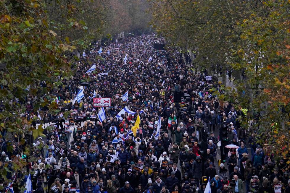 Protesters holding placards flags and banners, including the flag of Israel, during an anti-Sem ...