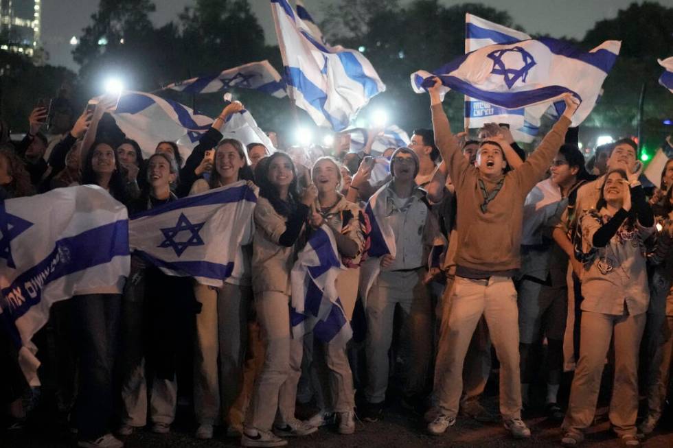 A group of Israelis celebrate as a helicopter carrying hostages released from the Gaza Strip la ...