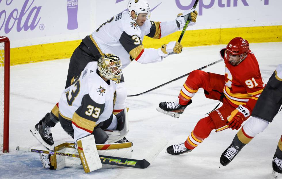 Vegas Golden Knights defenseman Brayden McNabb, top left, checks Calgary Flames forward Nazem K ...