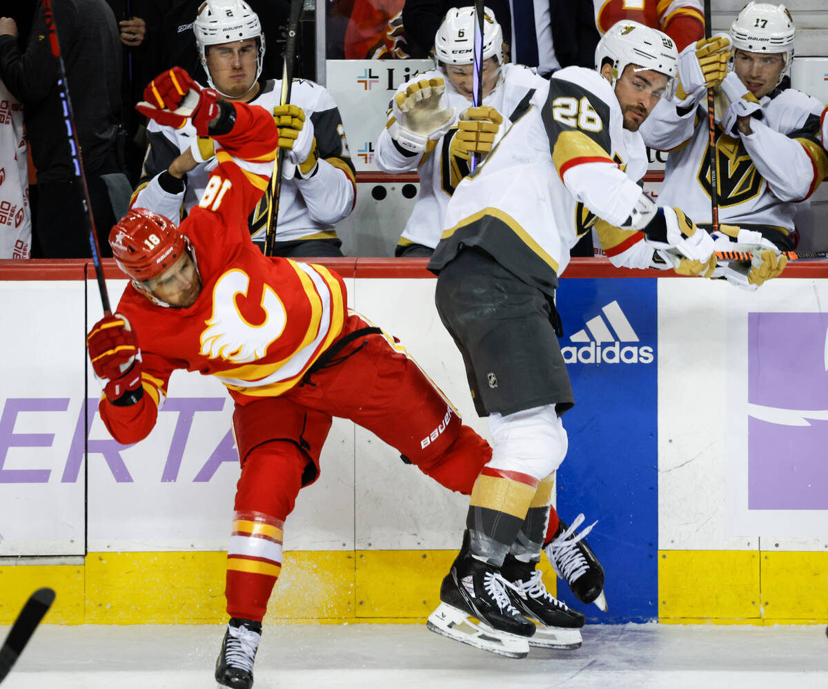 Vegas Golden Knights forward William Carrier, right, checks Calgary Flames forward A.J. Greer, ...