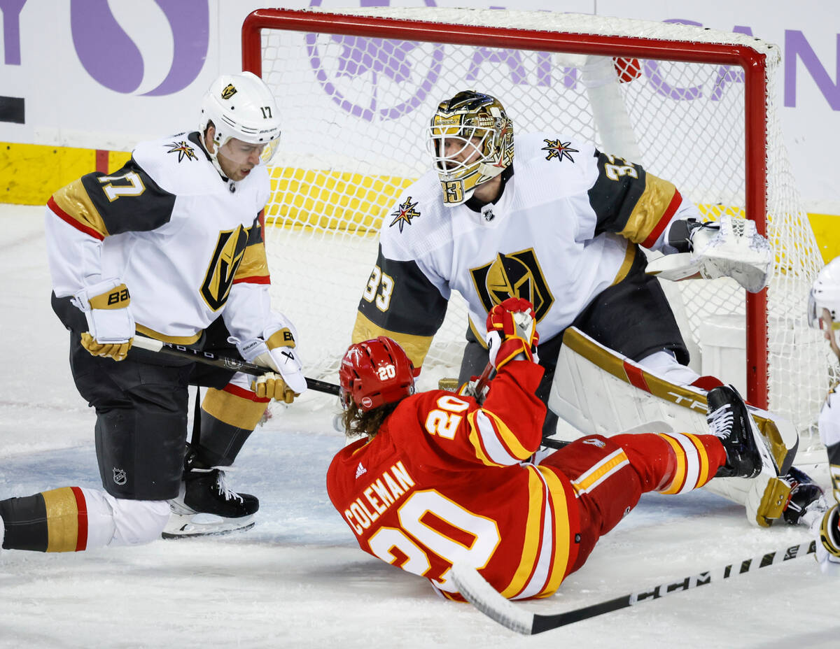 Vegas Golden Knights defenseman Ben Hutton, left, takes out Calgary Flames forward Blake Colema ...