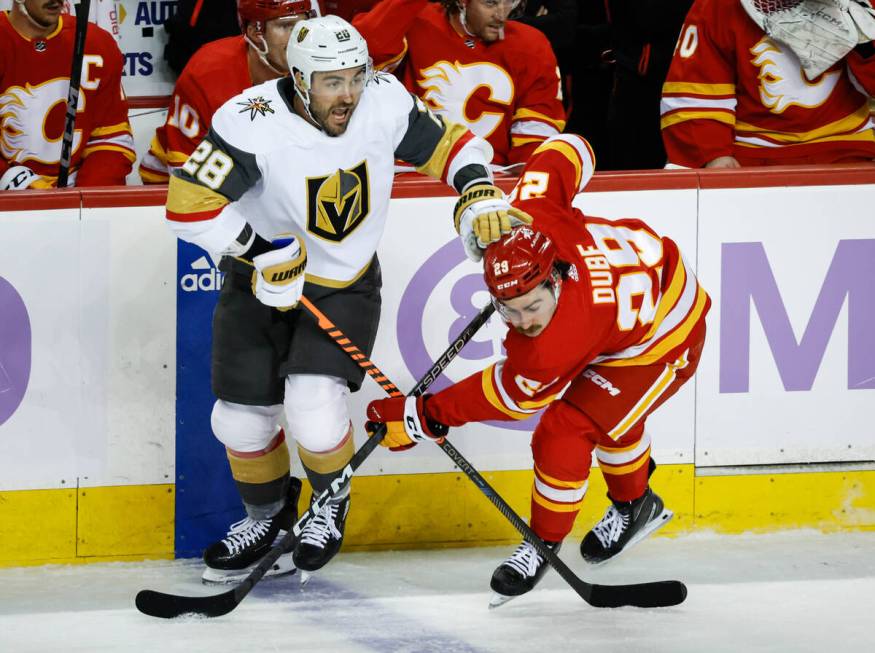 Vegas Golden Knights forward William Carrier, left, pushes away Calgary Flames forward Dillon D ...