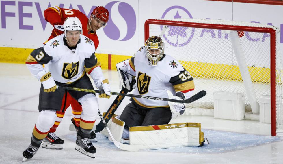 Vegas Golden Knights defenseman Brayden McNabb, front left, checks Calgary Flames forward Jonat ...