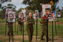 Israeli soldiers look at photos of people killed and taken captive by Hamas militants during th ...