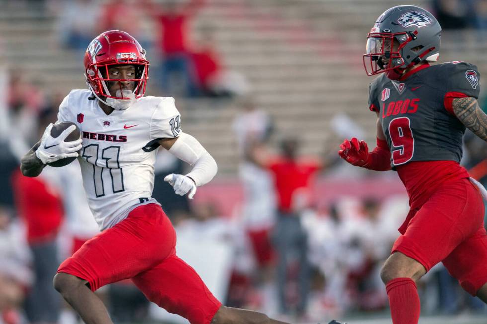 UNLV's Ricky White, left, looks back at New Mexico's Noa Pola-Gates, right, while running a rec ...