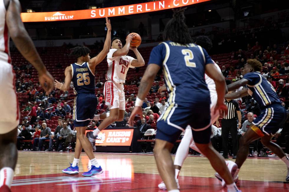 UNLV Rebels guard Dedan Thomas Jr. (11) jumps to shoot against Akron Zips forward Enrique Freem ...