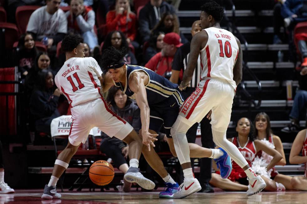 UNLV Rebels guard Dedan Thomas Jr. (11) and forward Kalib Boone (10) force Akron Zips forward E ...