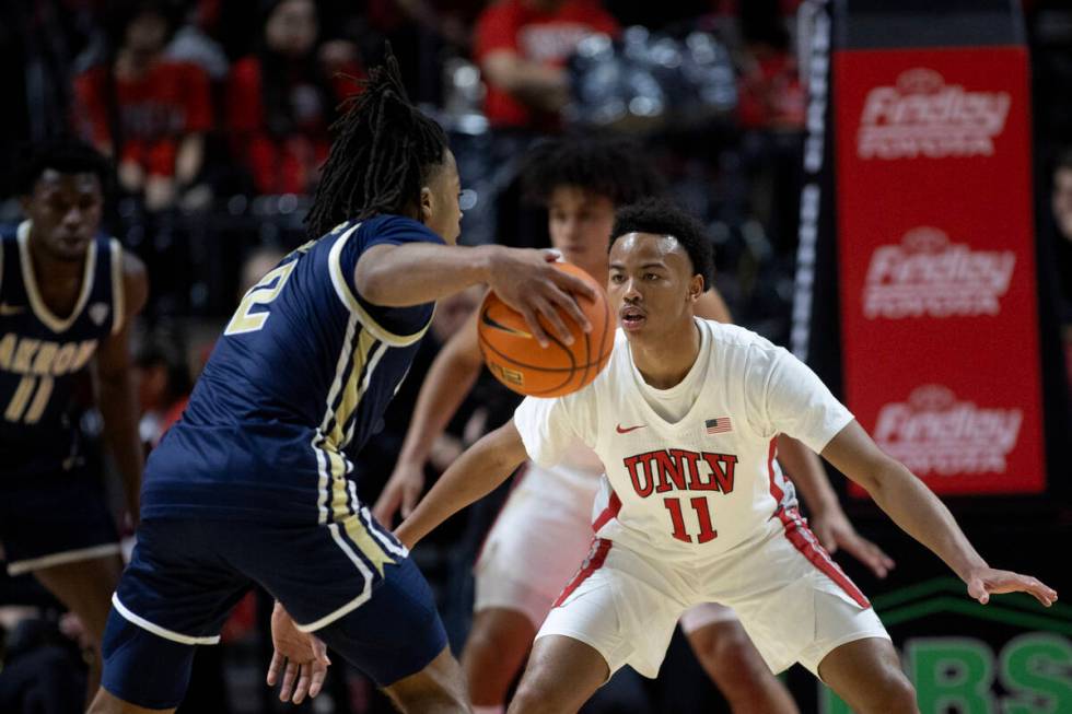 UNLV Rebels guard Dedan Thomas Jr. (11) defends against Akron Zips guard Greg Tribble (2) durin ...