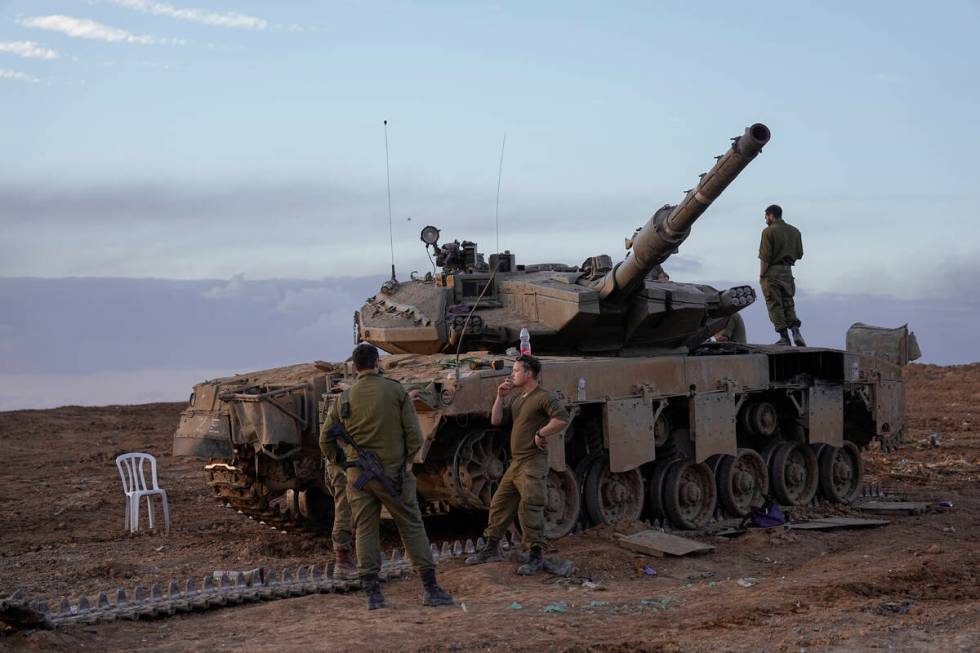 Israeli soldiers work on a tank near the border with the Gaza Strip, southern Israel, Tuesday, ...