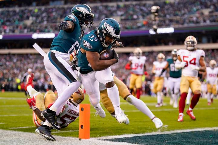 Philadelphia Eagles running back Boston Scott, center, runs for a touchdown during the first ha ...