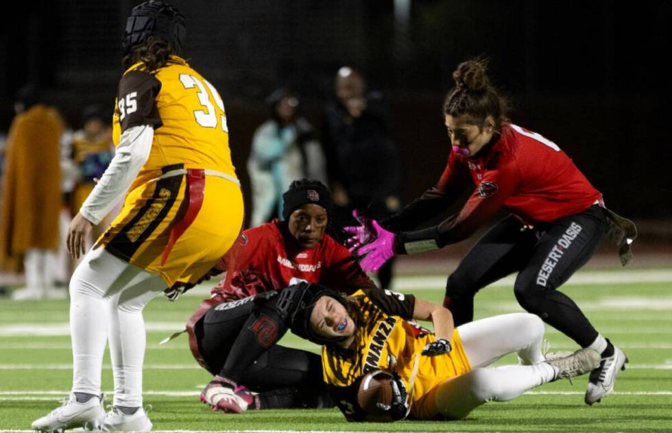 Bonanza’s Reagan Coupe (3) is taken down by Desert Oasis linebackers Lillian Felise, center l ...