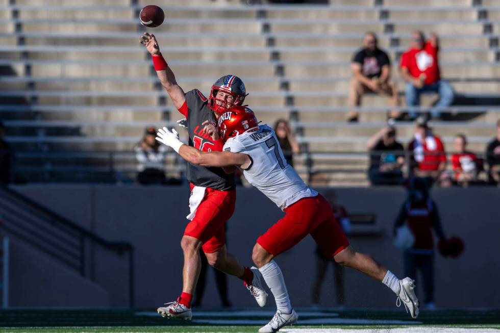 New Mexico quarterback Dylan Hopkins gets rid of the ball before being hit by UNLV's Jackson Wo ...