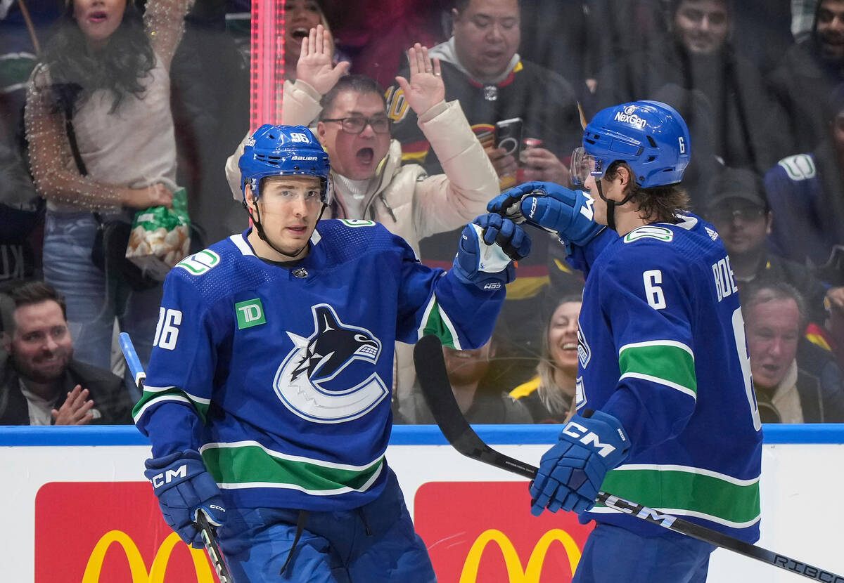 Vancouver Canucks' Andrei Kuzmenko, left, and Brock Boeser celebrate Kuzmenko's goal against th ...