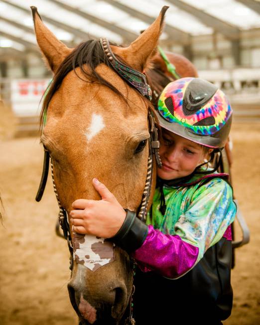 Rori Fenner hugs her Buckskin gelding Mr Star Bogie "Bucky" in thanks after winning a race in W ...