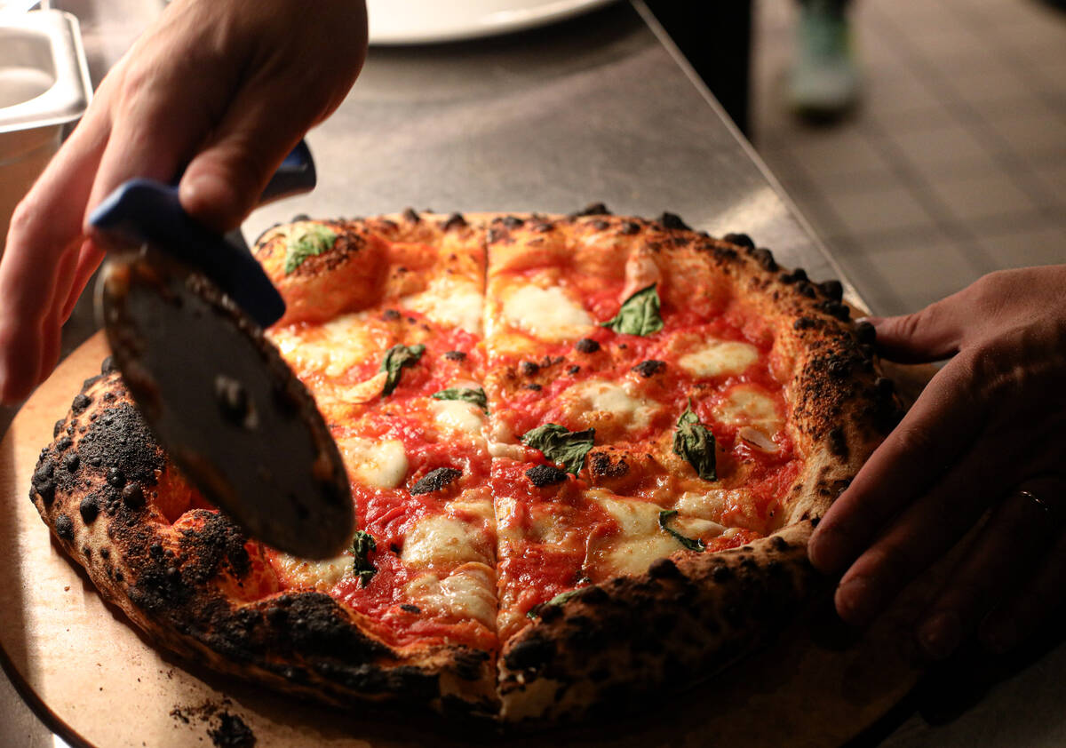 World champion pizza maker Michael Vakneen slices a pizza at his new restaurant, ØØ Pie & Pub ...