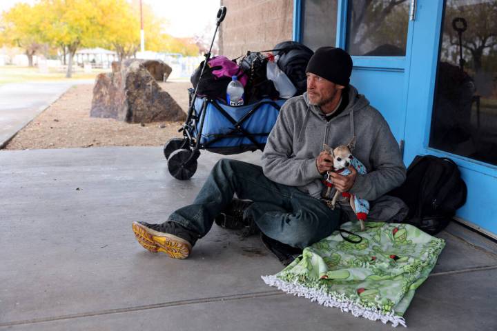 Gregory Lee Ellis, 47, and his friend’s dog Kiki relax at Downtown Park in Henderson Fri ...