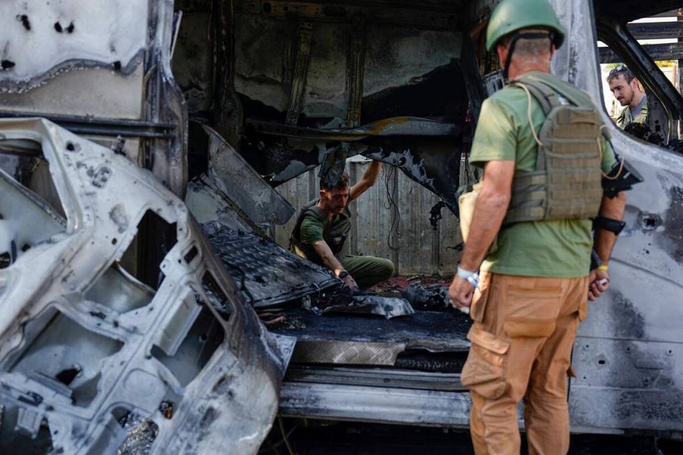 Israeli security personal inspect a site hit by a rocket fired from the Gaza Strip, In a commun ...