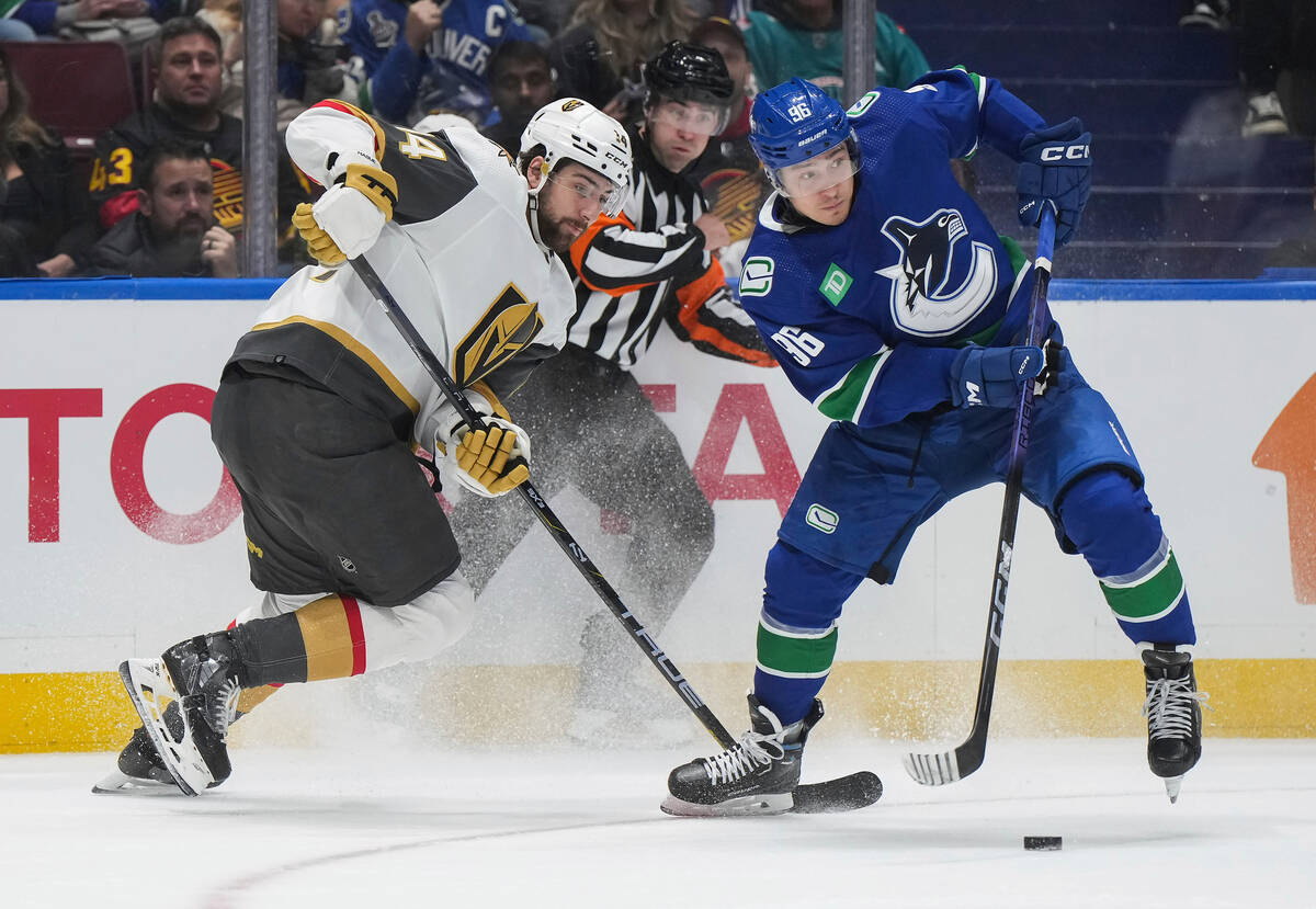 Vancouver Canucks' Andrei Kuzmenko, right, takes the puck from Vegas Golden Knights' Nicolas Ha ...