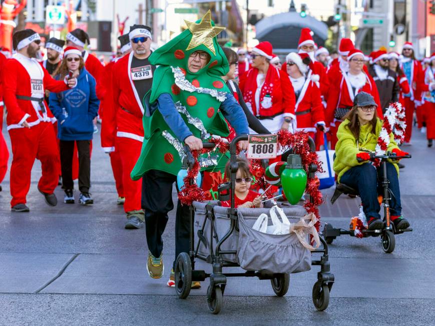 Participants walk to the starting line during the Las Vegas Great Santa Run through downtown on ...