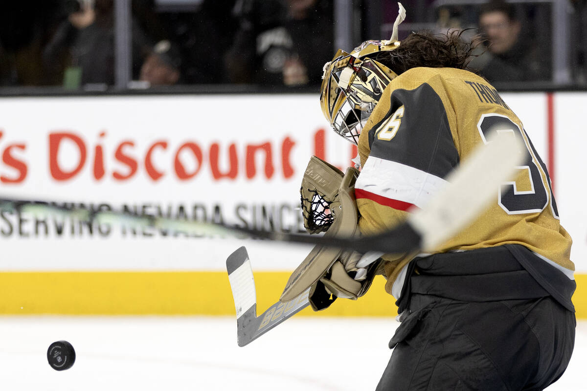 Golden Knights goaltender Logan Thompson (36) loses his helmet while saving the puck during the ...