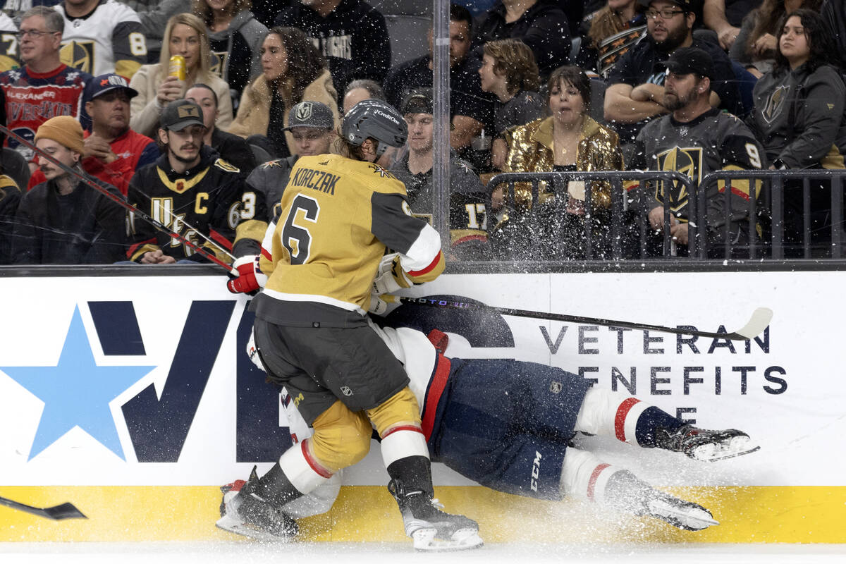 Golden Knights defenseman Kaedan Korczak (6) slams Capitals center Dylan Strome (17) into the b ...