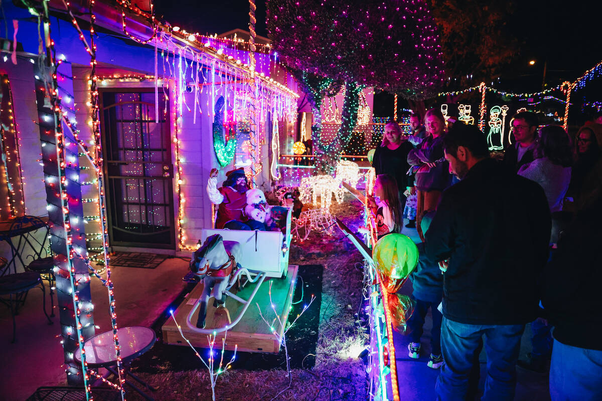 People admire Christmas decorations in the yard of Dale Ryan and Dyanah Musgrave on Sunday, Dec ...