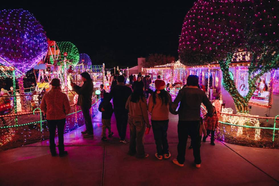 People stroll through the yard of Dale Ryan and Dyanah Musgrave on Sunday, Dec. 3, 2023, in Bou ...