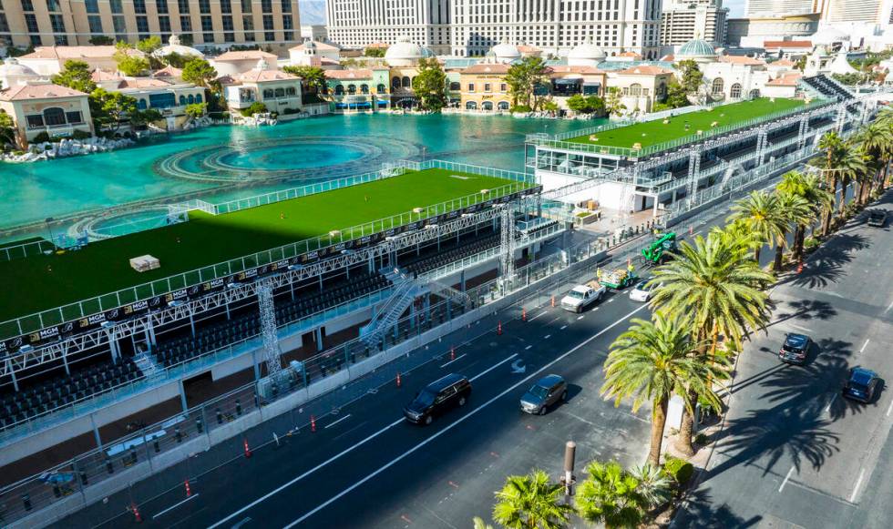 Workers add the finishing touches on the Formula One grandstands at the lake in front of Bellag ...