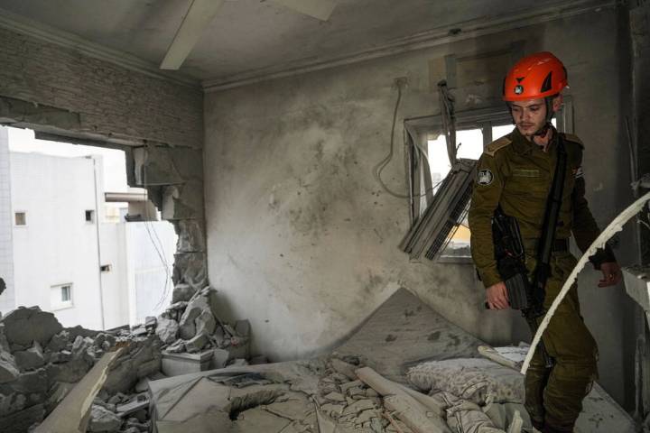 Israeli security forces inspect a residential building after it was hit by a rocket fired from ...