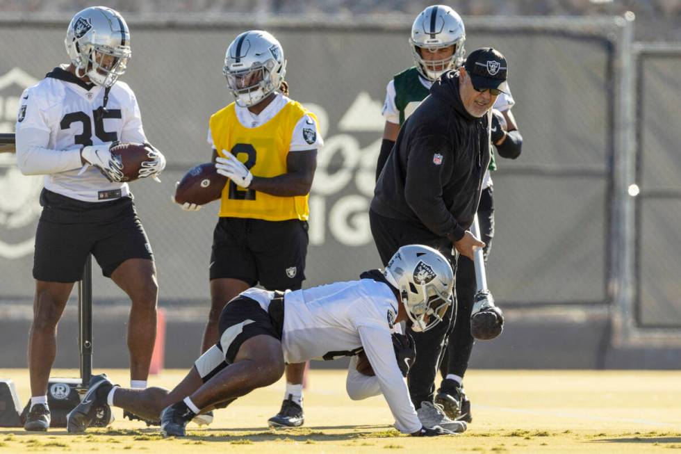 Raiders running back Josh Jacobs (8) pushes up from the ground to run with running back coach K ...