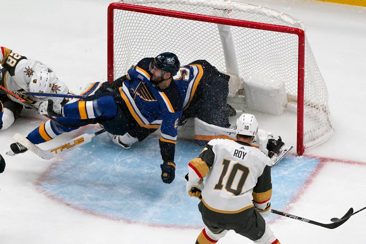 St. Louis Blues' Marco Scandella, left, falls as Vegas Golden Knights' Nicolas Roy (10) watches ...