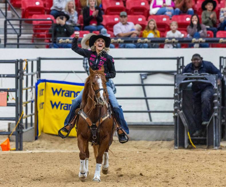 Sarah Angelone of Stephenville, Texas, reacts to roping a calf in record time during the NFR br ...