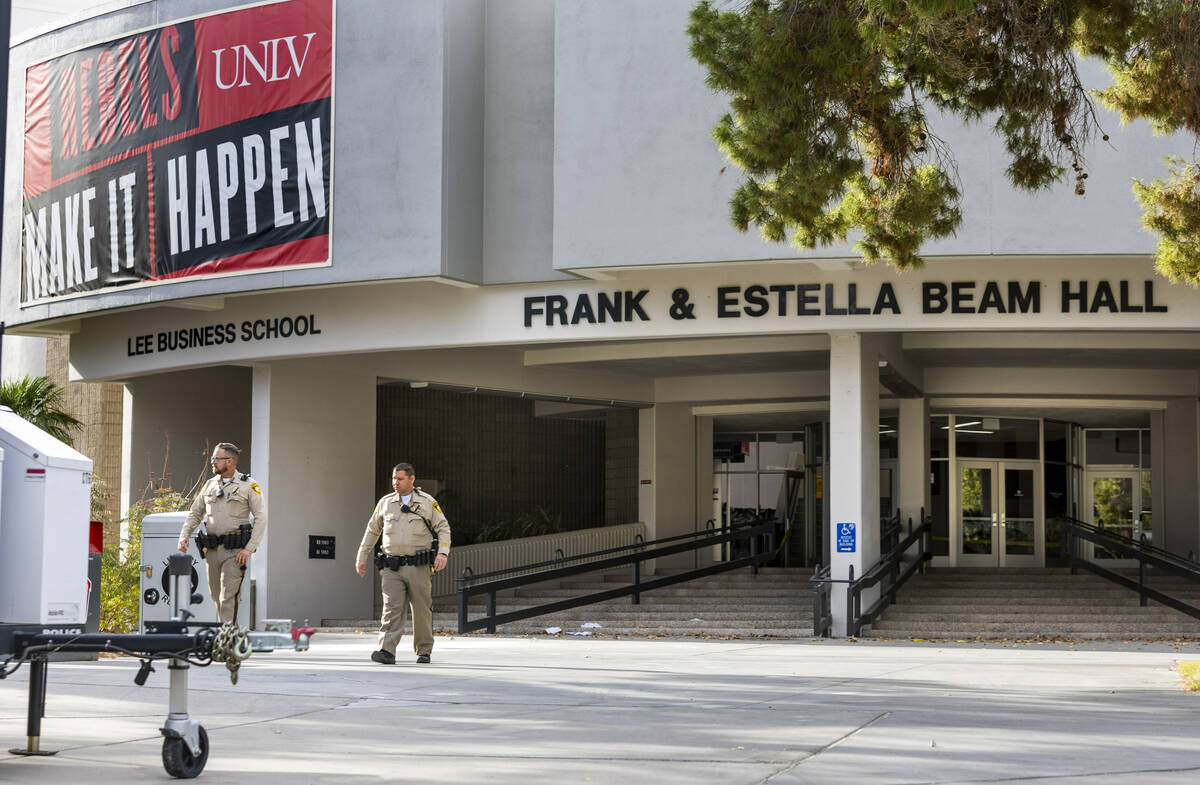 Metro officers walk near the entrance to the Frank and Estella Beam Hall following the shooting ...