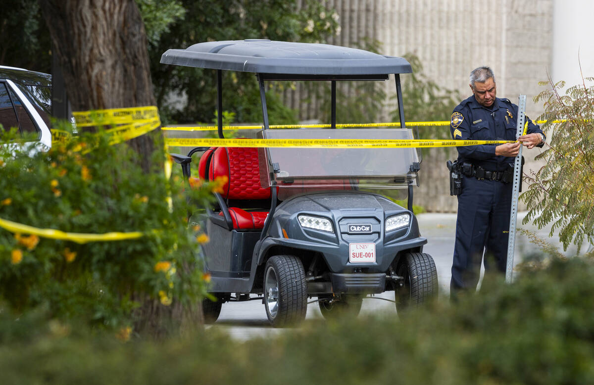 A University Police officer unties some police tape outside the Student Union following the sh ...