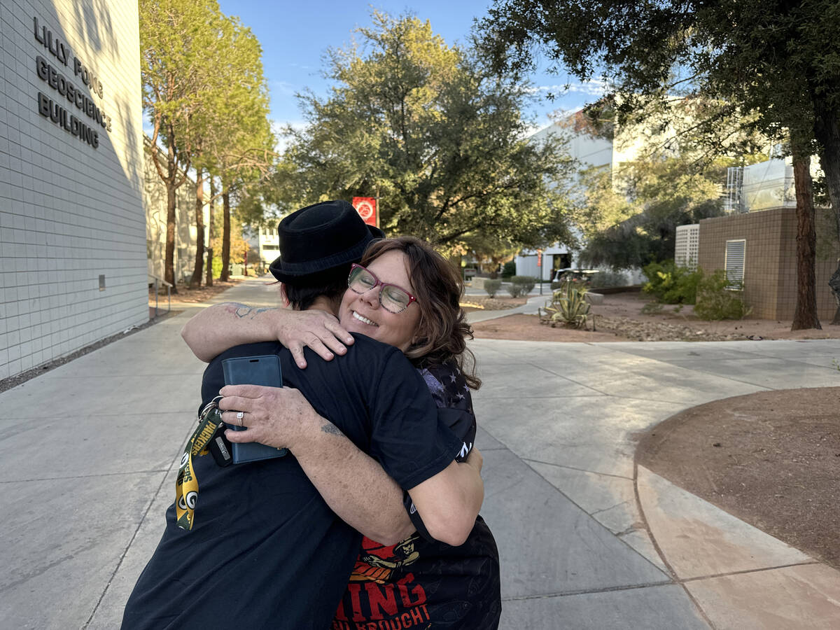 Staff members Gregory Galindo and April Fikstad hug on the UNLV campus in Las Vegas Thursday, D ...