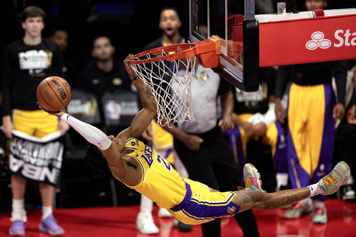 Los Angeles Lakers forward Maxwell Lewis (21) attempts to tip his dunk in, but is charged with ...