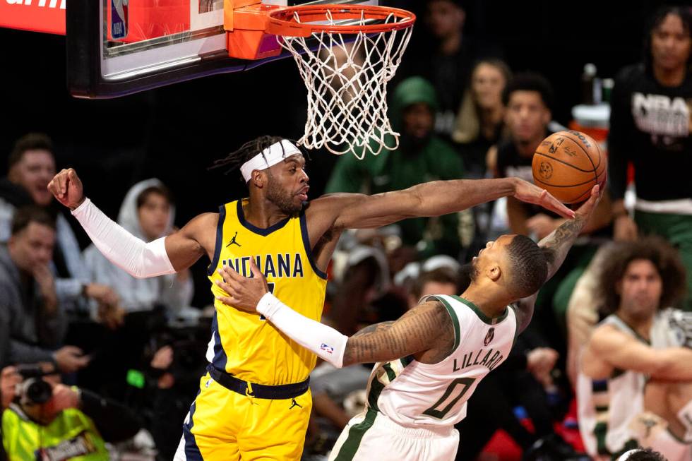 Indiana Pacers guard Buddy Hield (7) thwarts a shot by Milwaukee Bucks guard Damian Lillard (0) ...